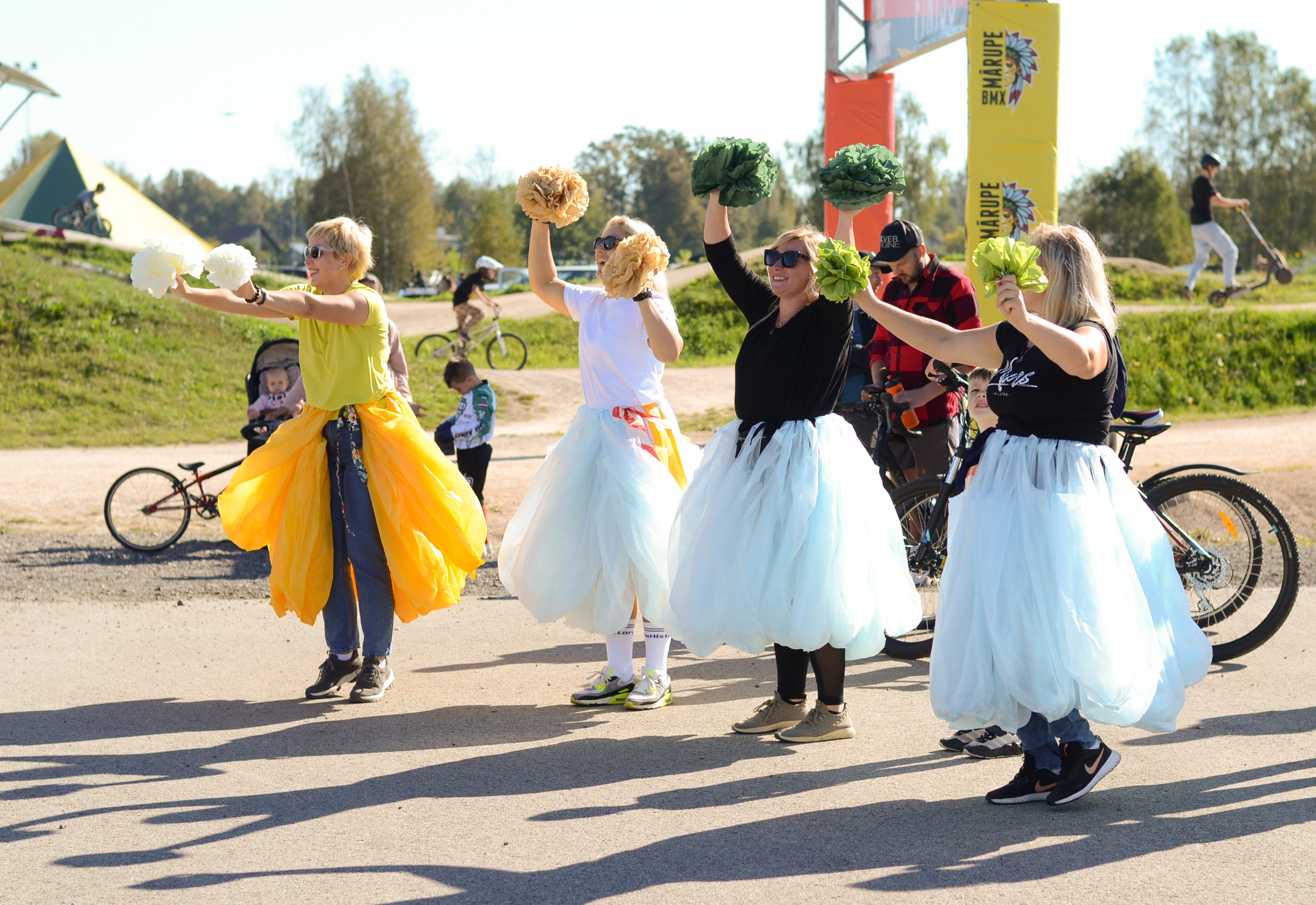 Sievietes tilla svārkos māj pārējiem festivāla apmeklētājiem