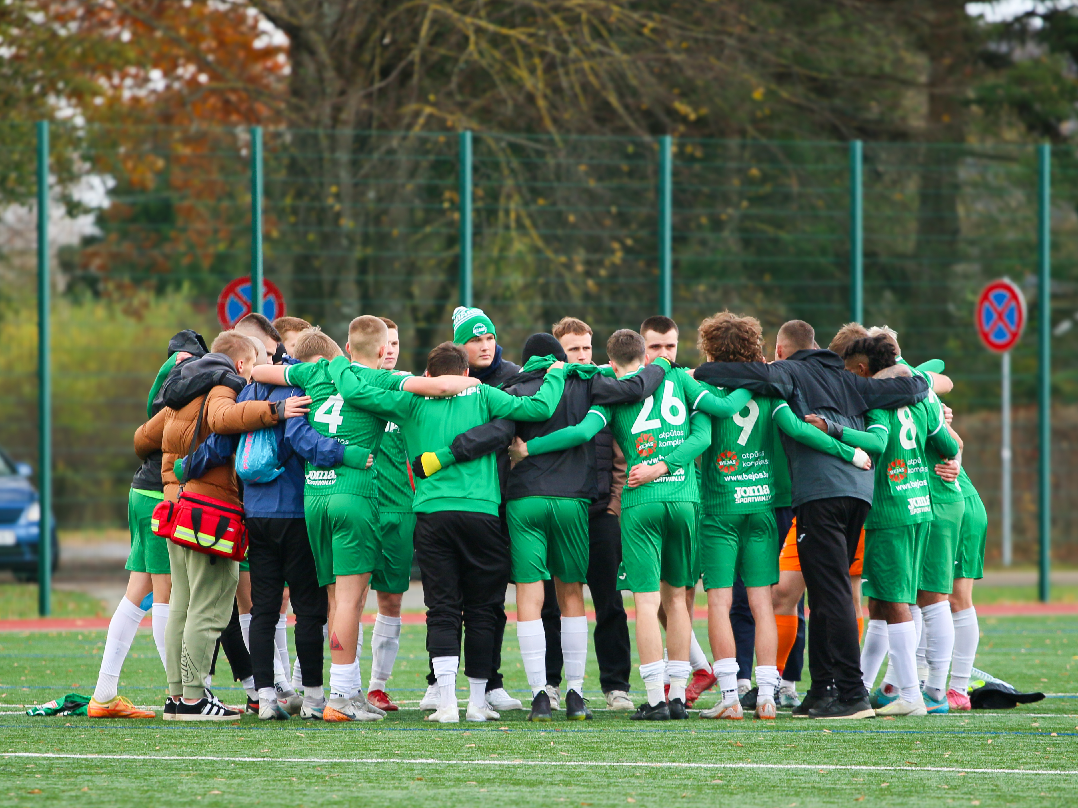 Futbolisti stāv aplī un apķērušies