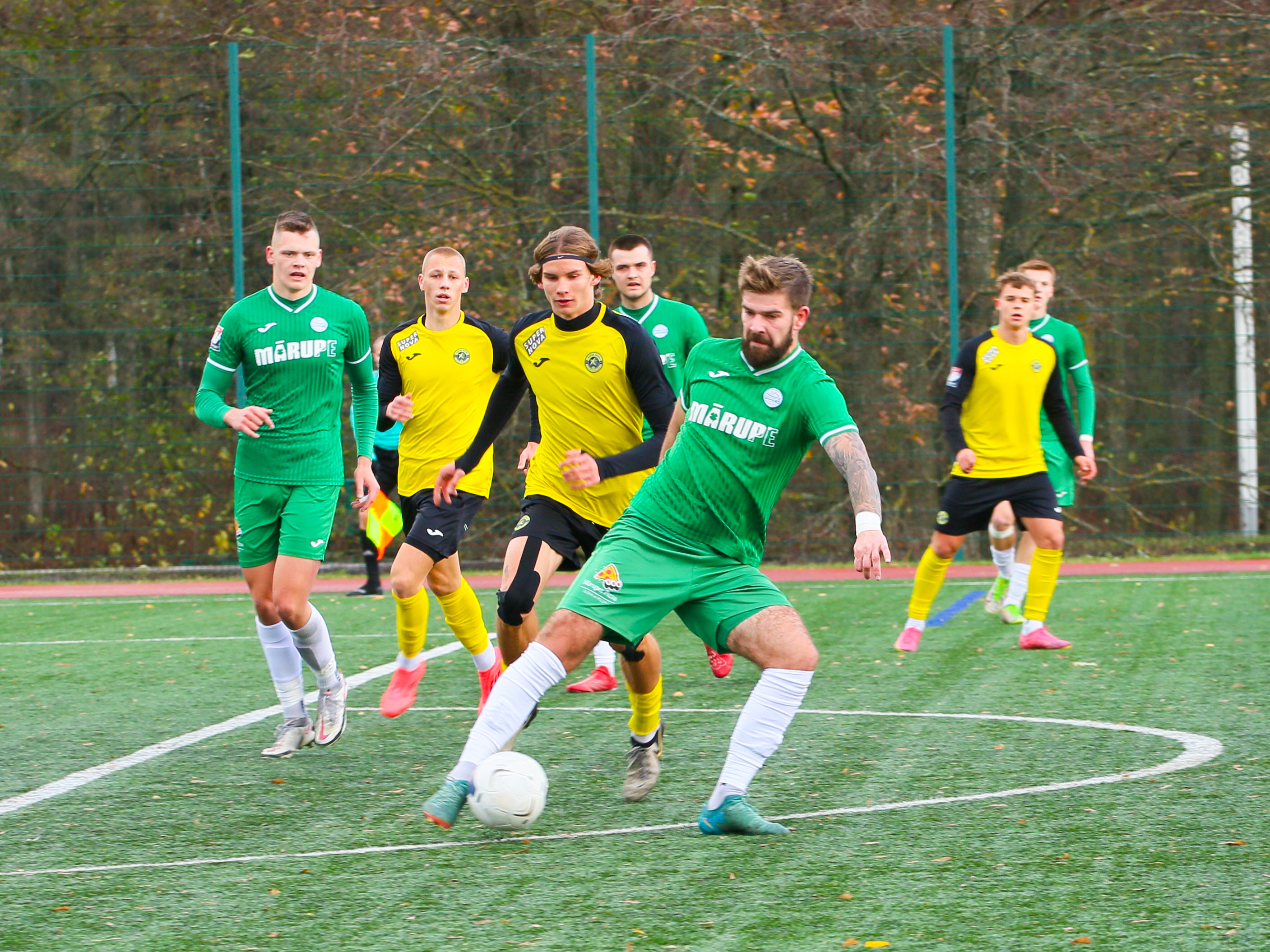 Futbolisti cīnās par bumbu futbola laukumā