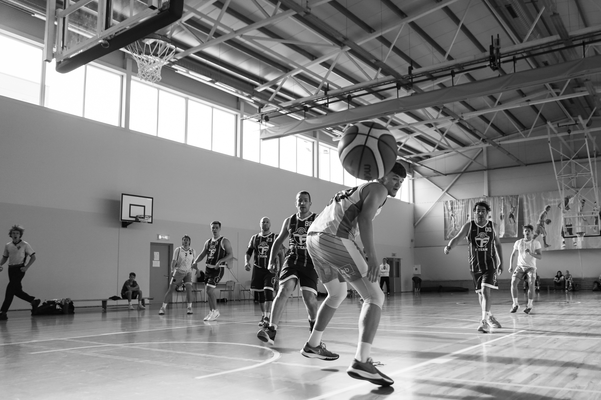 Vairāki basketbolisti laukumā cīnās par basketbola bumbu