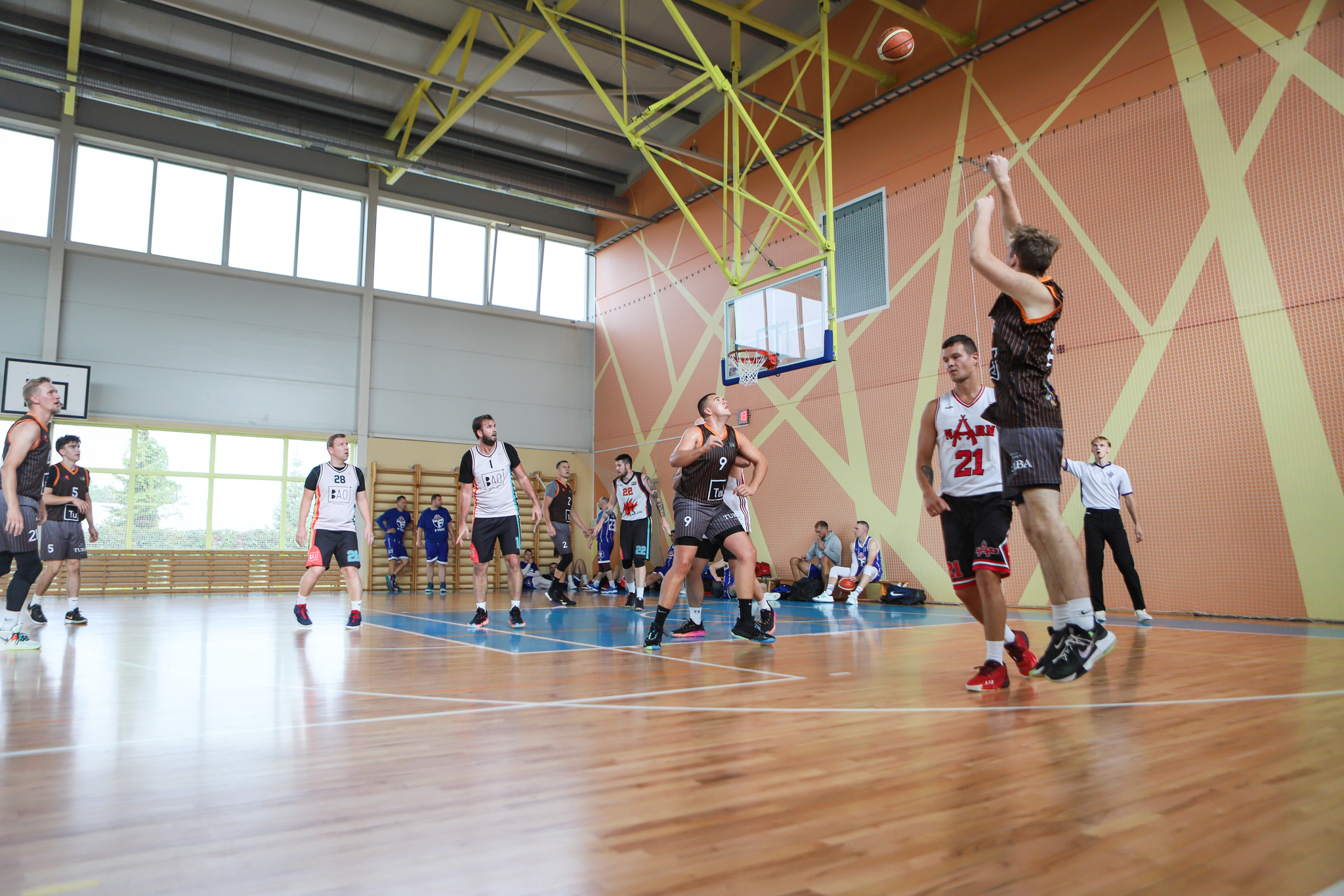 Vairāki basketbolisti laukumā cīnās par basketbola bumbu