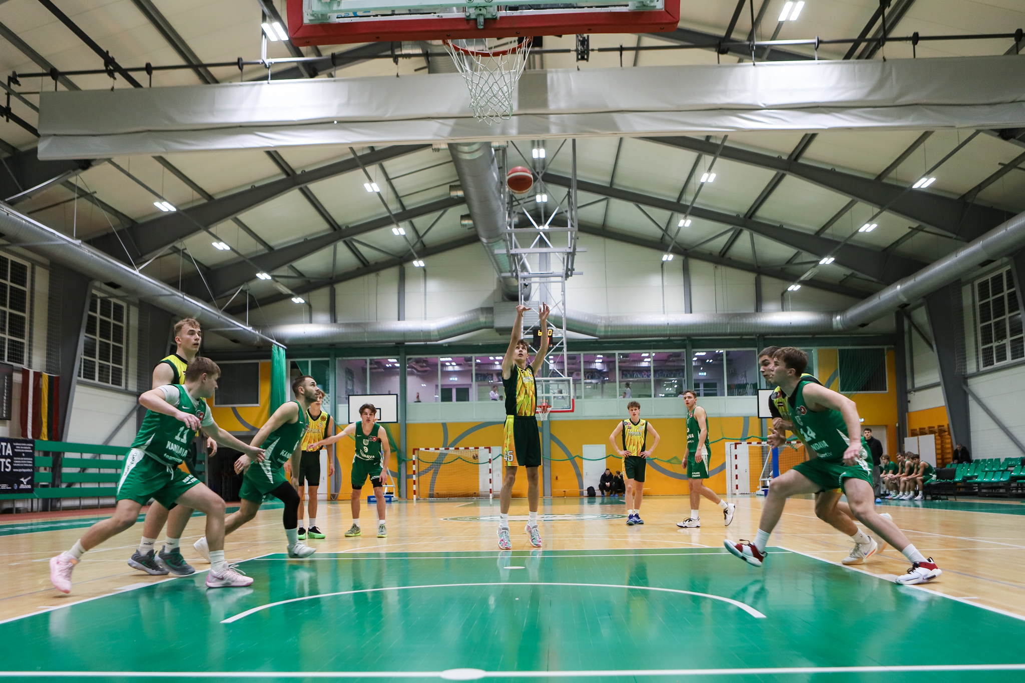 Basketbolisti spēlē sporta zālē