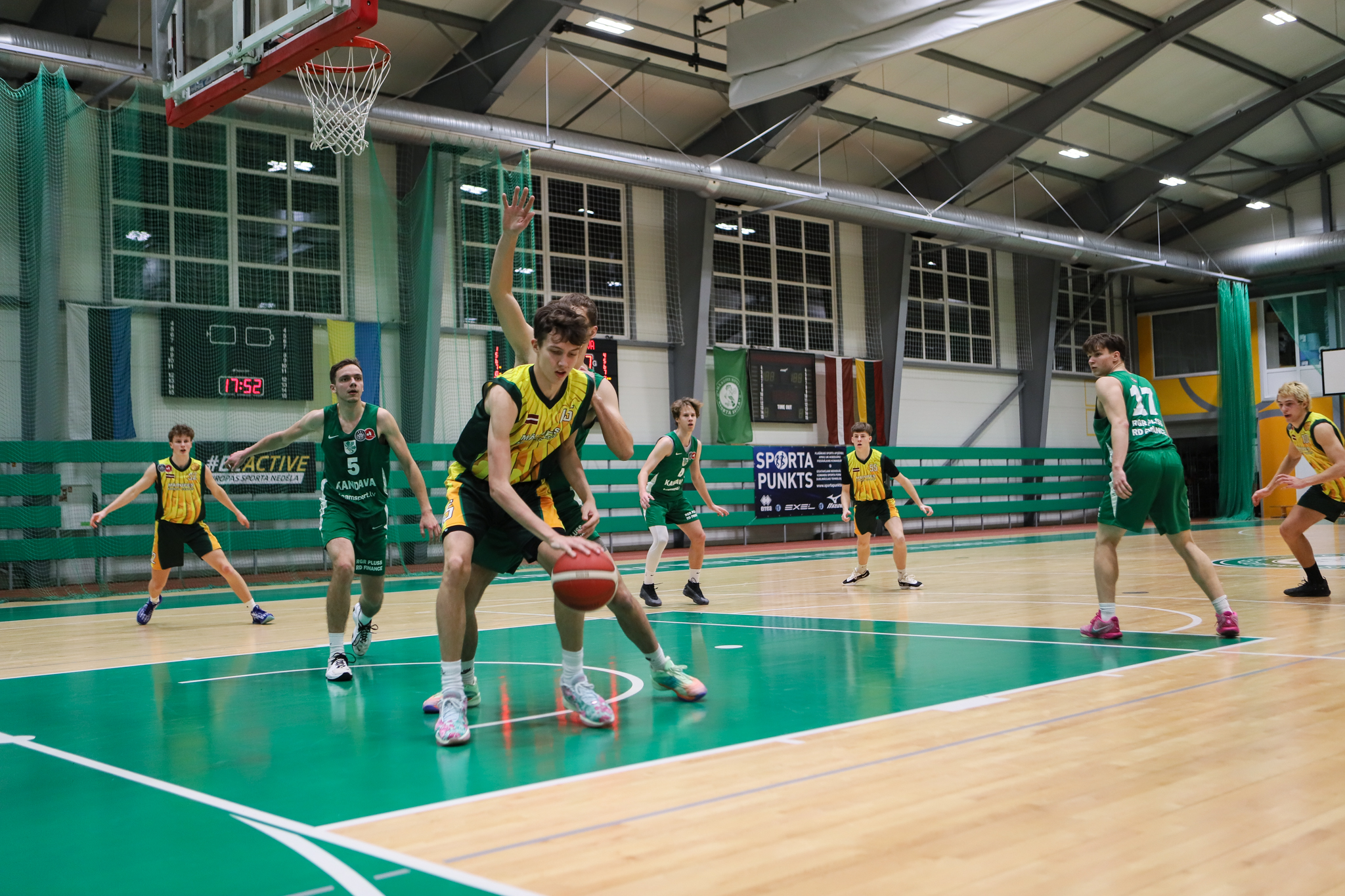 Basketbolisti spēlē sporta zālē