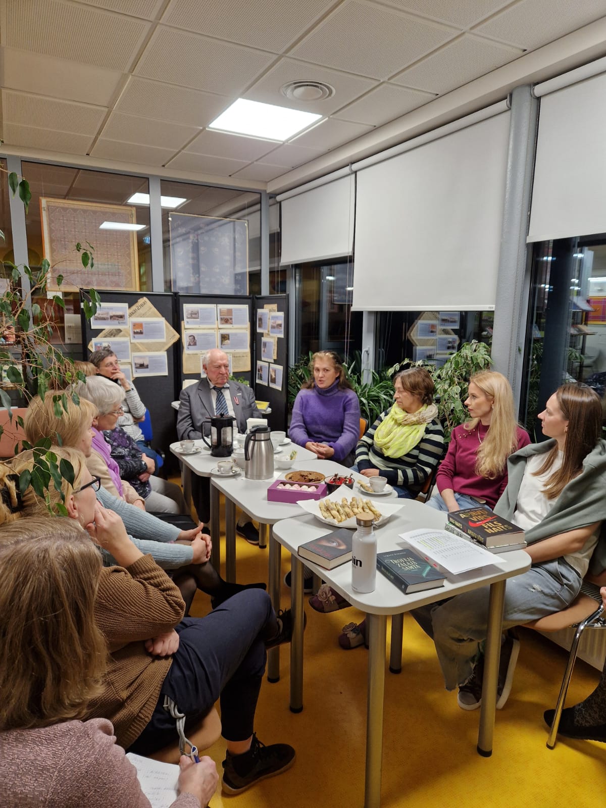 Grāmatu klubiņa dalībnieki ap grāmatu galdu