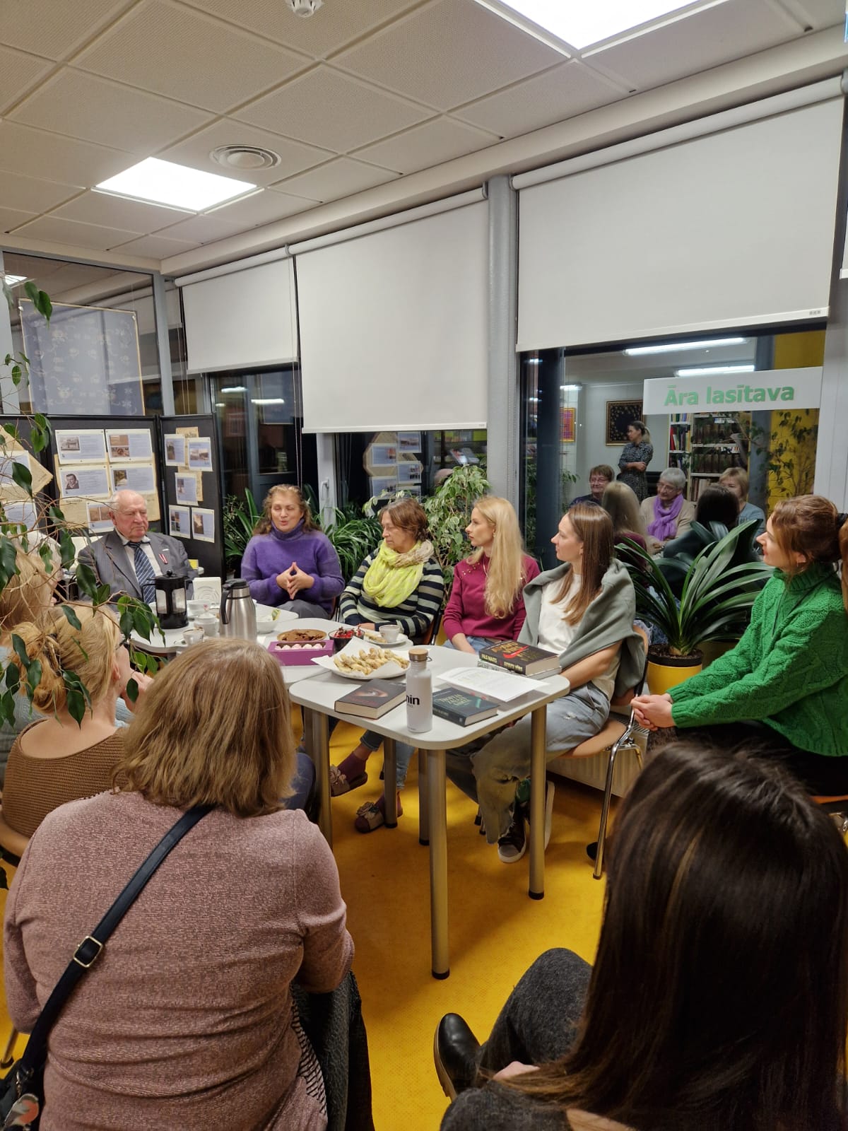 Grāmatu klubiņa dalībnieki ap grāmatu galdu