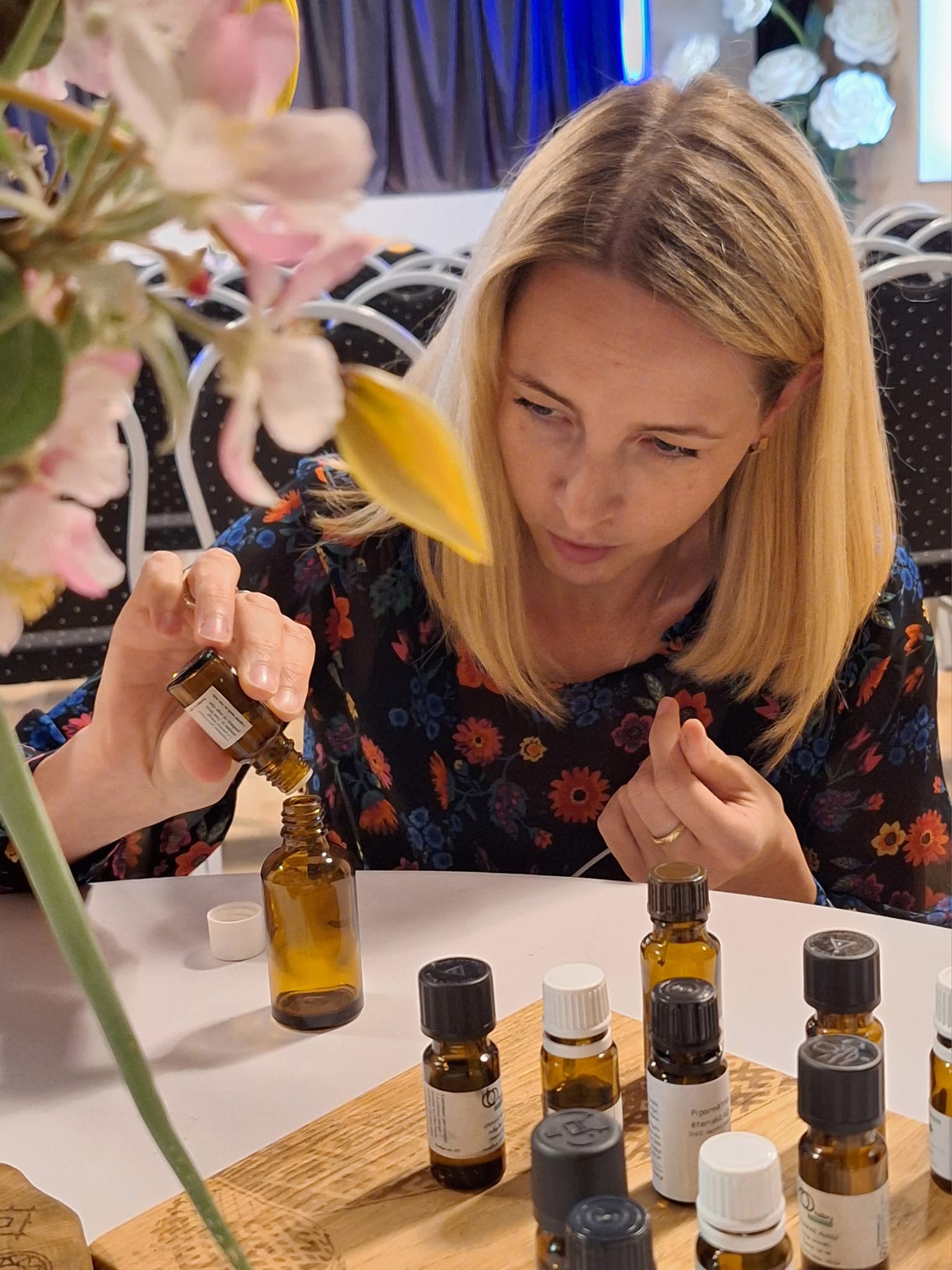Sieviete pie galda veido radošajā darbnīcā smaržu eļļas