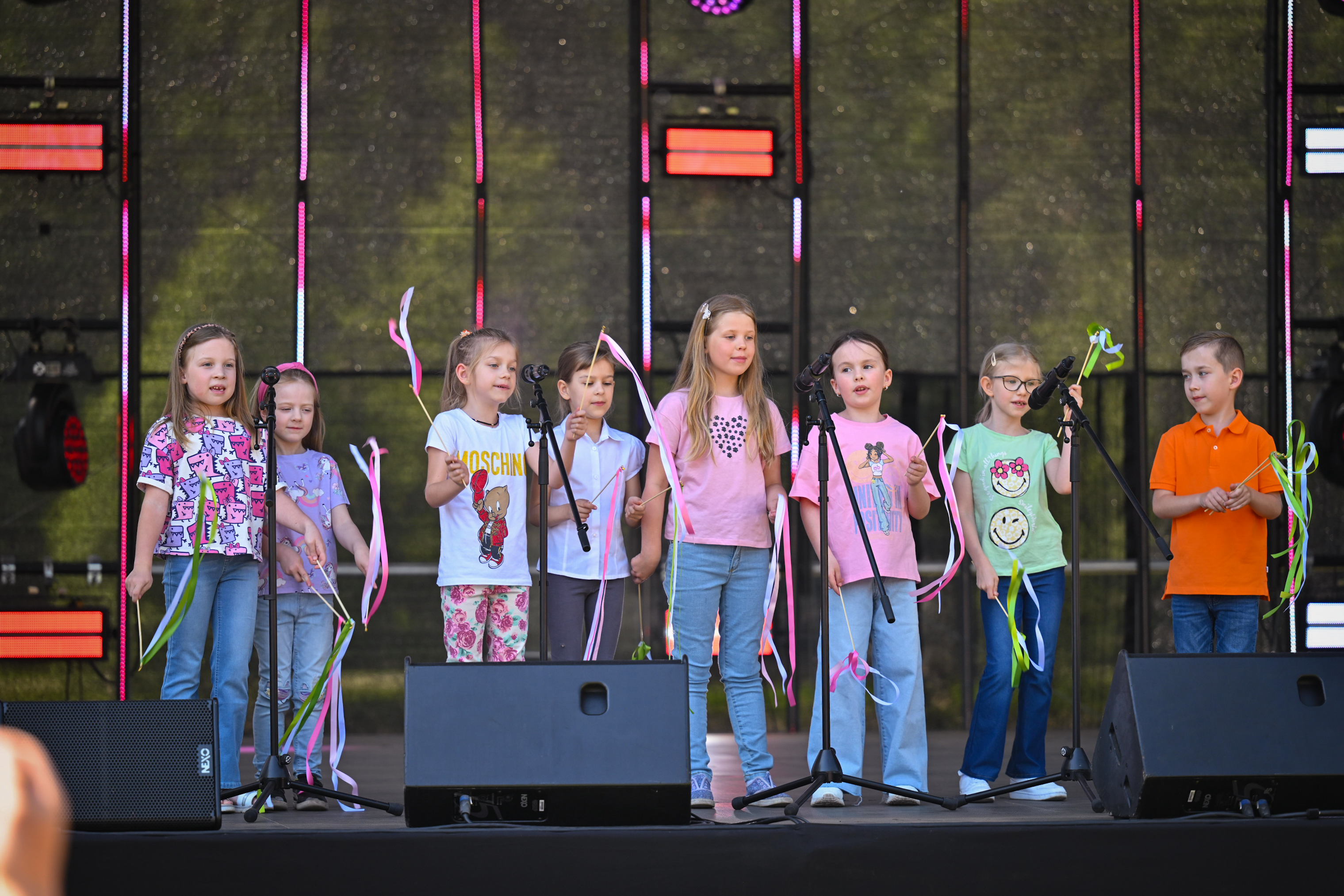 Bērnu popgrupa krāsainos tērpos uz skatuves