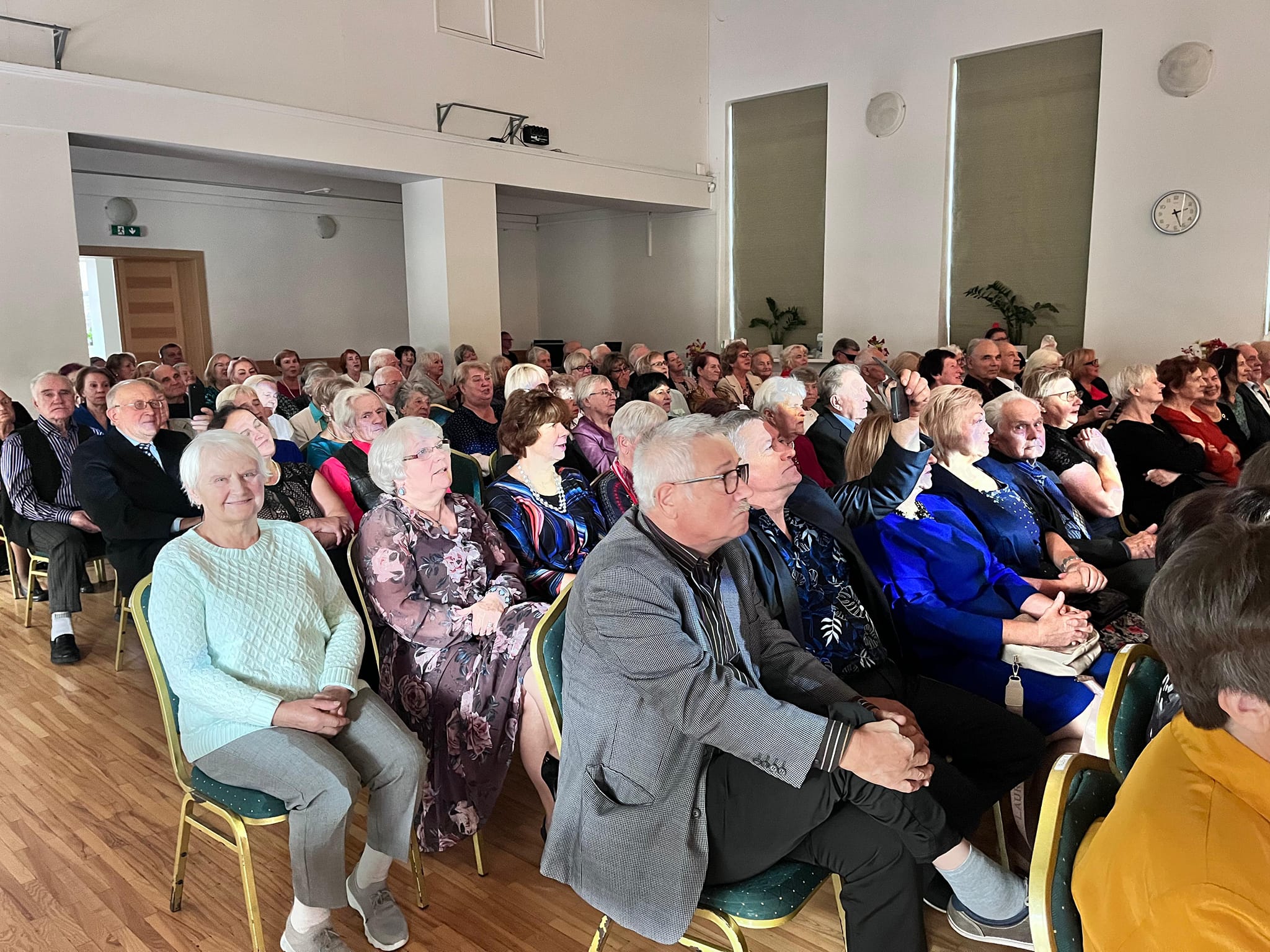 Senioru pulks pasākuma zālē sēdvietās