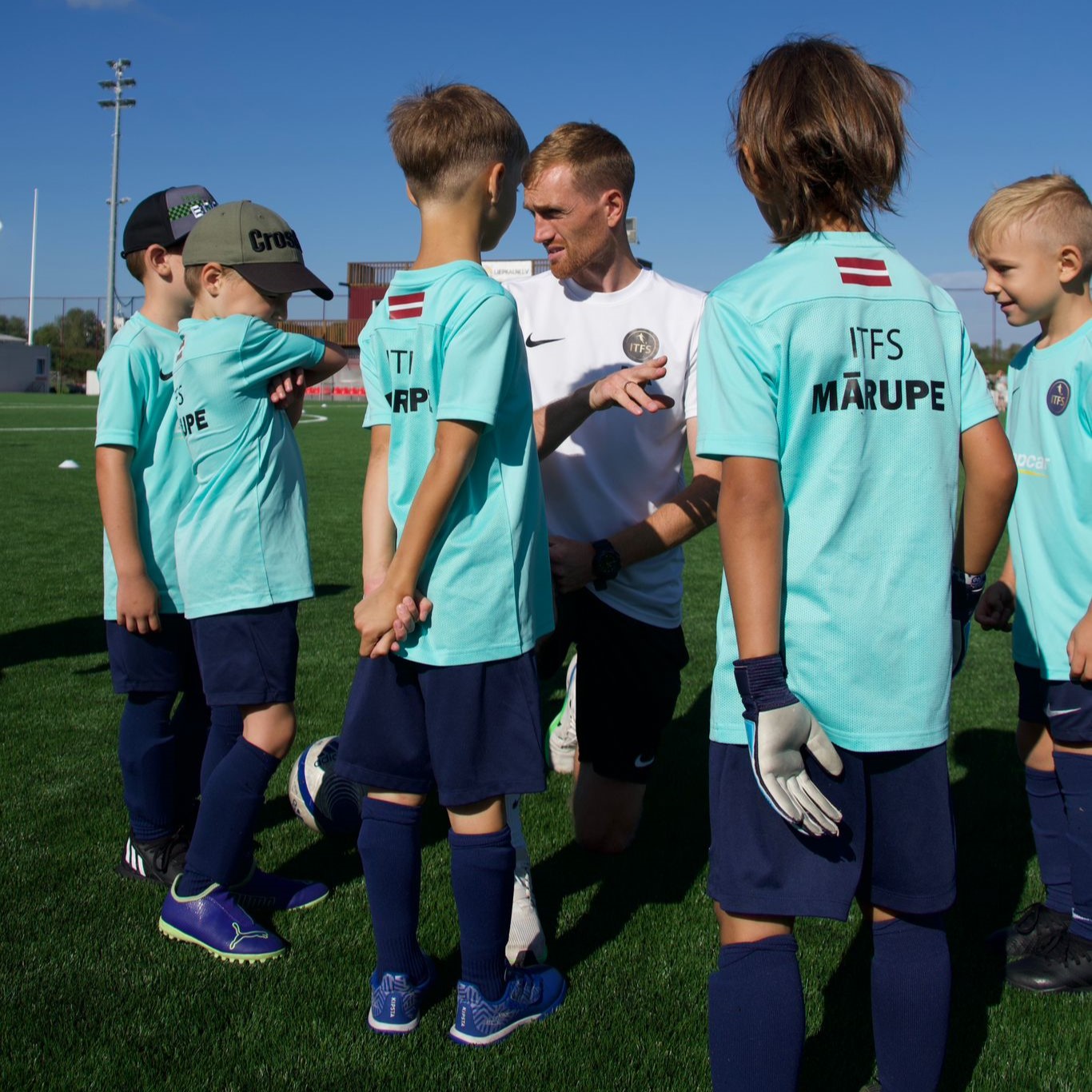 Mazi bērni zilos kreklus futbola laukumā