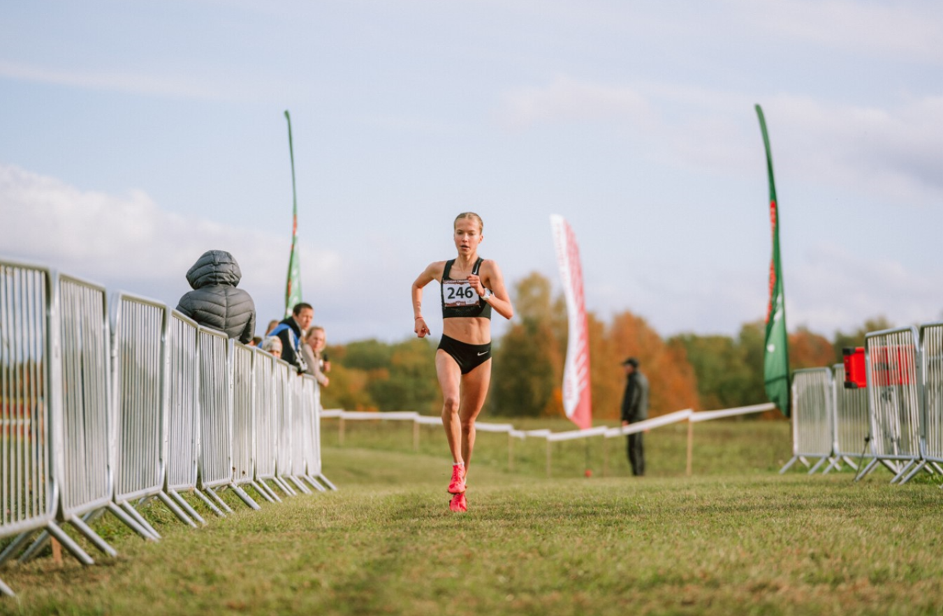 Meitene sporta tērpā skrien pa taku