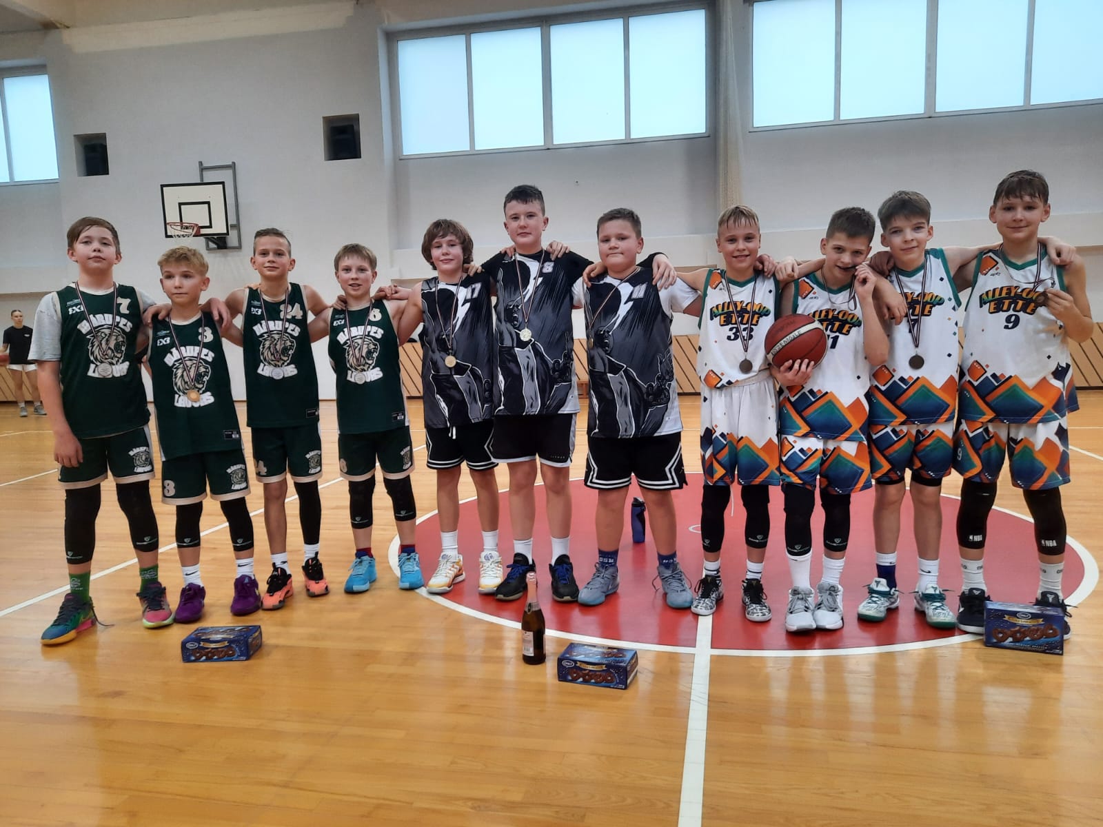 Basketbolisti stāv rindā sporta zālē