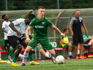 Mārupes SC komandas spēlētājs zaļā komandas tērpā ar baltu futbola bumbu pie kājām.