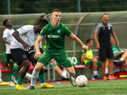 Mārupes SC komandas spēlētājs zaļā komandas tērpā ar baltu futbola bumbu pie kājām.