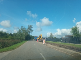 Asfaltēta ceļa posms remontdarbu laikā saulainā vasaras dienā