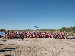 Cilvēku pūlis peldkostīmos pie ūdenstilpnes