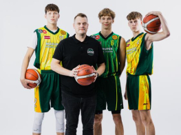 Trīs jauni puiši basketbola kreklos un ar basketbola bumbu rokā stāv blakus trenerim melnā apģērbā un ar basketbola bumbu rokās