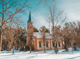 Brūns dievnams saulainā ziemas dienā