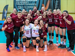 Vairākas meitenes bordo krāsas un baltos sporta tērpos volejbola sporta laukumā