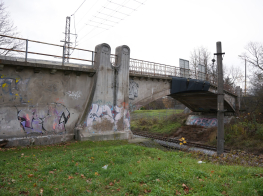 Pelēks betona satiksmes pārvads ar krāsainiem grafiti virsū