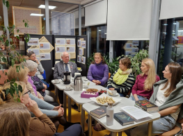 Grāmatu klubiņa dalībnieki pie galda ar grāmatām