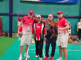 Četri vīrieši sporta tērpos stāv sporta zālē