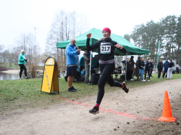 Sieviete skrien pa grants ceļu pāri finiša līnijai