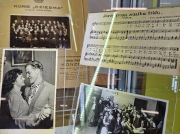 izstādes kartiņas vitrīnā aiz stikla