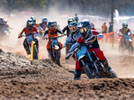 motokrosa braucēji brauc pa dubļu trasi