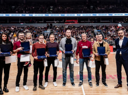 Vairāki cilvēki stāv basketbola laukumā